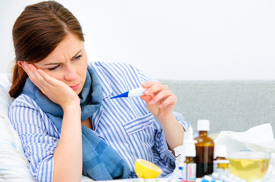 Nainen pitää kuumemittaria kädessään. Nainen pitää kuumemittaria kädessään.