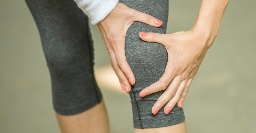 Henkiln jalat treenitrikoissa. Henkil pit ksilln toisesta polvesta kiinni.