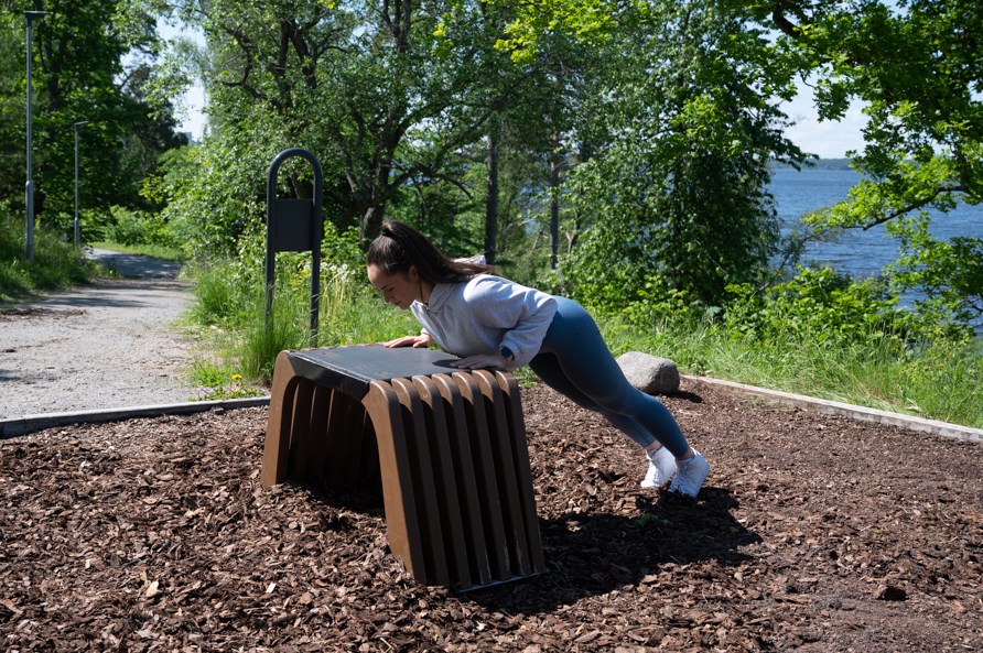 Nainen suorittaa punnerruksia.