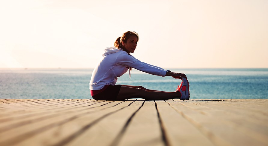 Tytt istuu laiturilla ja venyttelee.