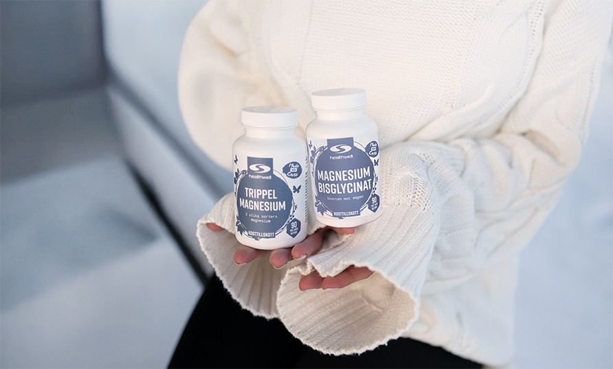 Nainen istuu ksissn kaksi purkkia magnesium-ravintolisi.